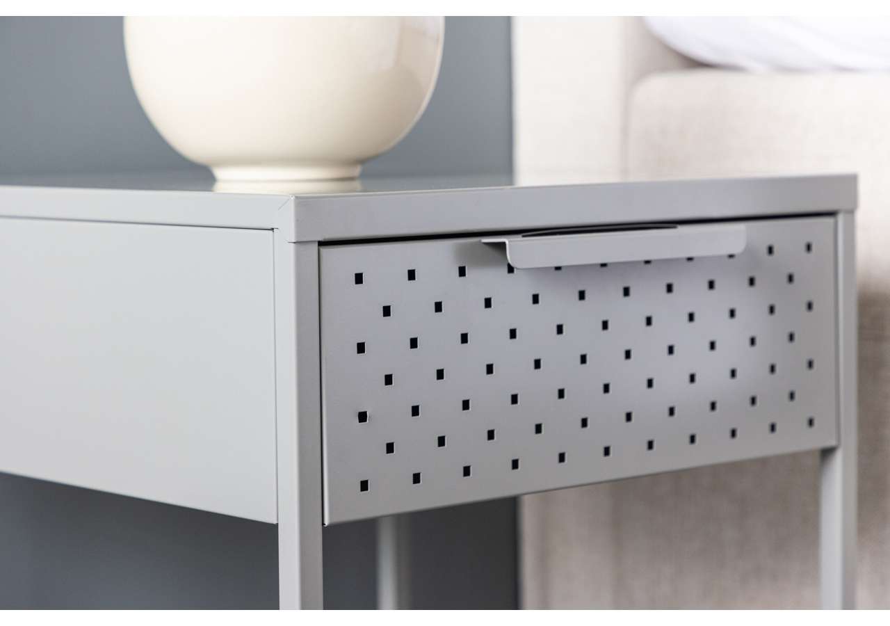 Rustfritt sängbord med perforerad front och modern design.