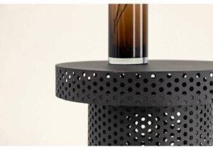 Modern svart metallbord med perforerad design för exklusiv inredning.