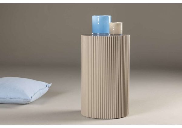 Modernt sidobord i beige med ribbad struktur och två färgglada glaslyktor på toppen.