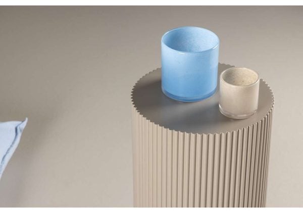 Höga krukor i blå och beige på modern sidobord med ribbad design.