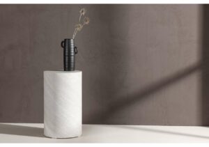 Elegant svart vas med blommor på vit marmorskiva, minimalistisk inredningsdetalj.