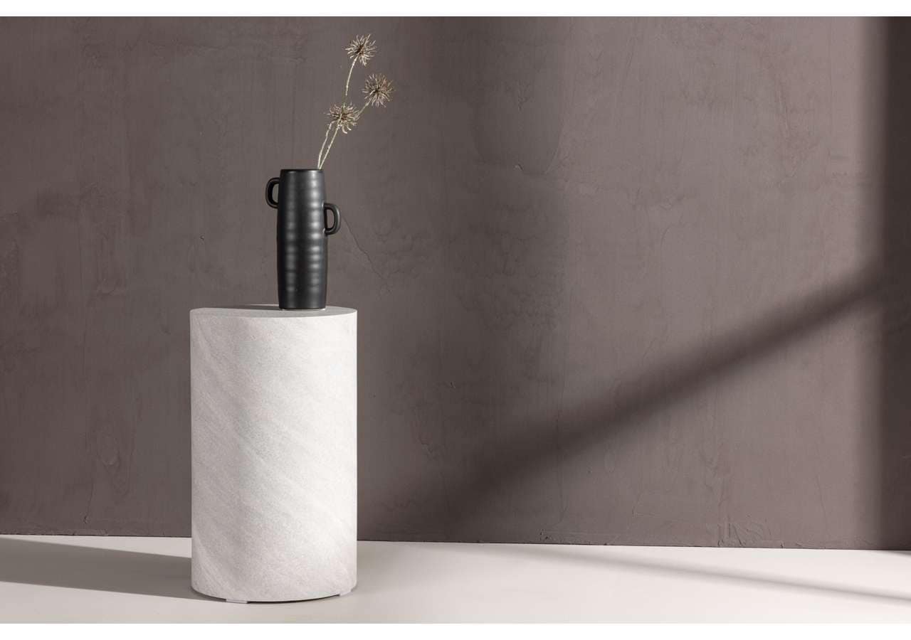 Elegant svart vas med blommor på vit marmorskiva, minimalistisk inredningsdetalj.