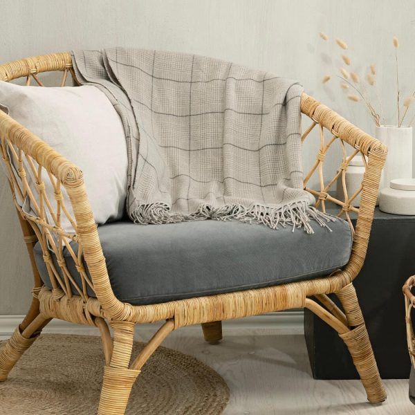 Mjukt bord med filten på, naturlig sittmöbel och stilren inredning.