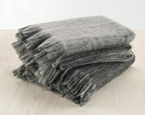 Mjukt filttäcke i grå nyans, perfekt för sovrum eller loungemiljö.