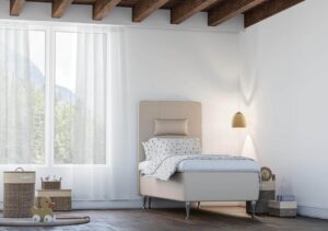 Lättskött säng med komfortabel madrass och stilrent tillbehör i behaglig sovrumsmiljö.