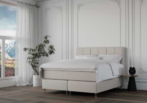 Rent sovrum med vit säng, elegant dekor och naturskön utsikt från fönster.