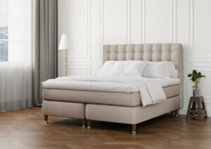 Sängfabriken, sängram i ljus beige med stoppad huvudgavel och vit sänggavel.