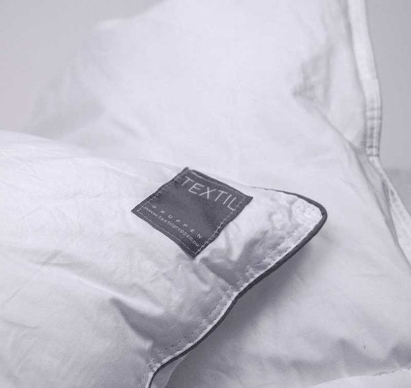Lakan med textiltäcke och kvalitetsmärkning för sängkomfort.