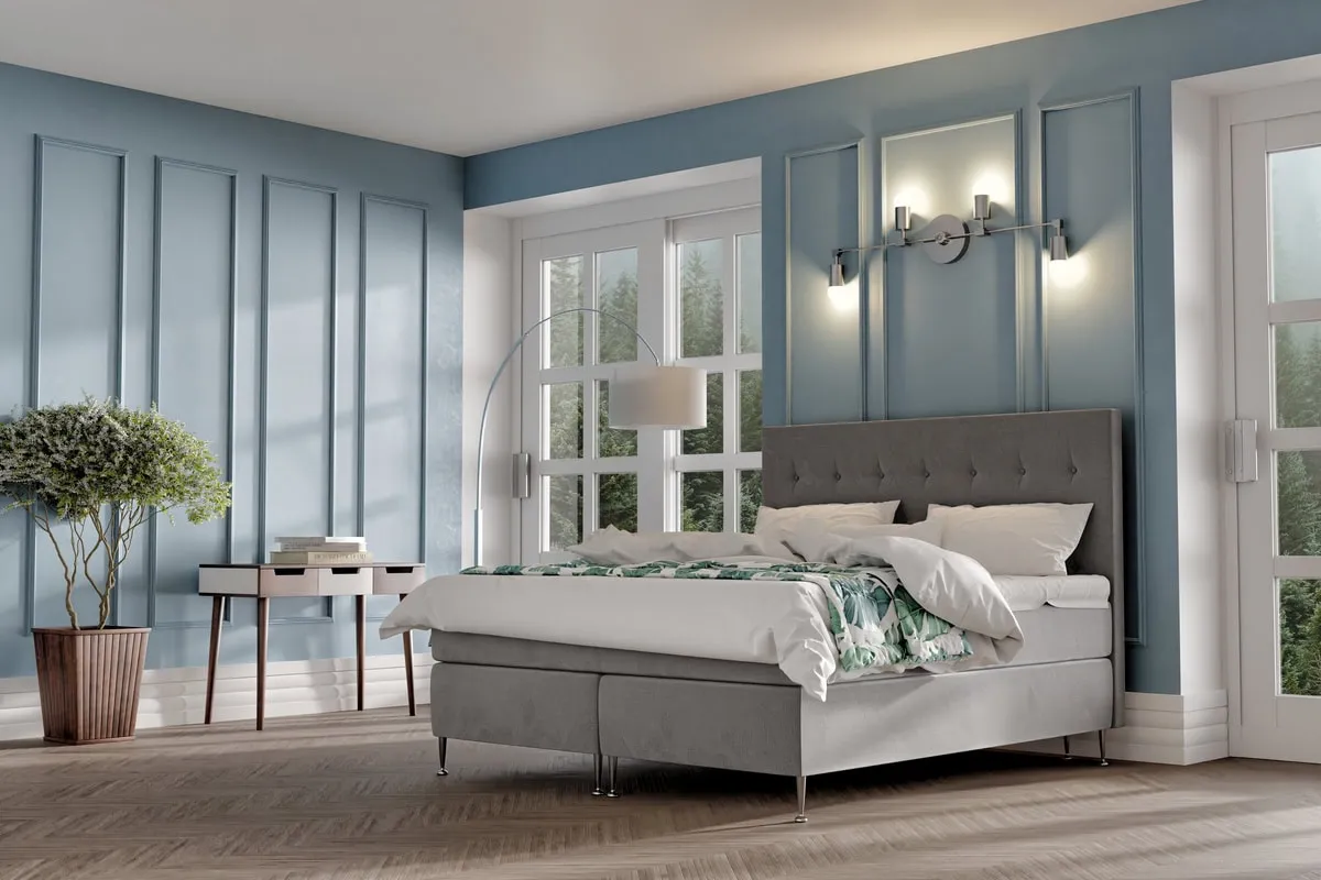 Mörkgrått sängram med kupat huvudgavel i modern sovrumsmiljö.