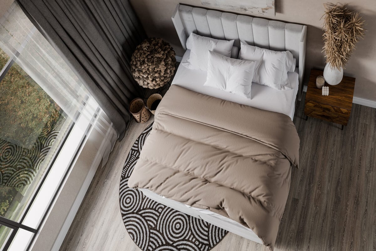 Sängfabriken, modern och bekväm säng med beige täcke och vita kuddar i ett stilrent sovrum.