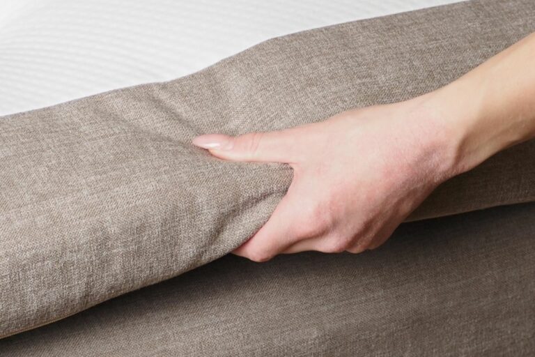 Högkvalitativ sängram i ljusbrunt tygmaterial.