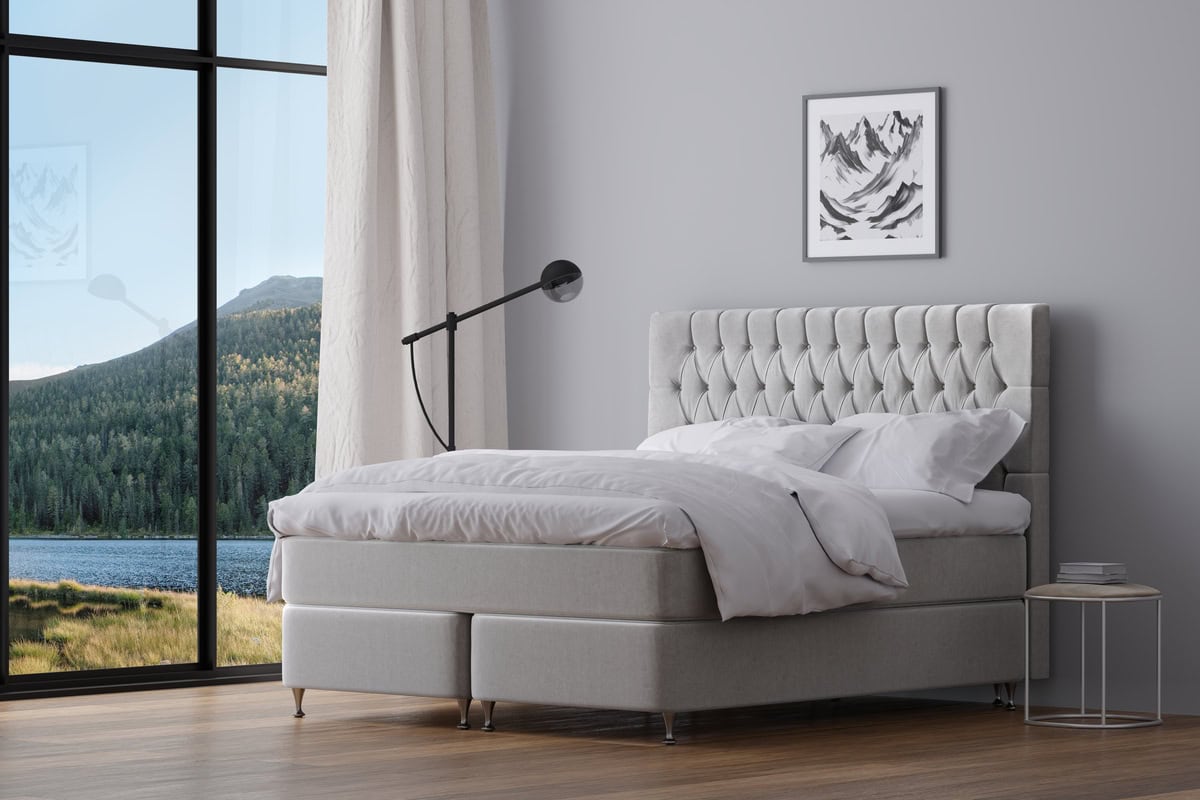 Ljus och modern säng med tuftad områdesgavel i ett elegant sovrum.