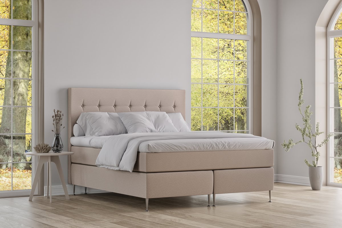 Ljust, stilrent sängram för kontemporär sovrumsmiljö.