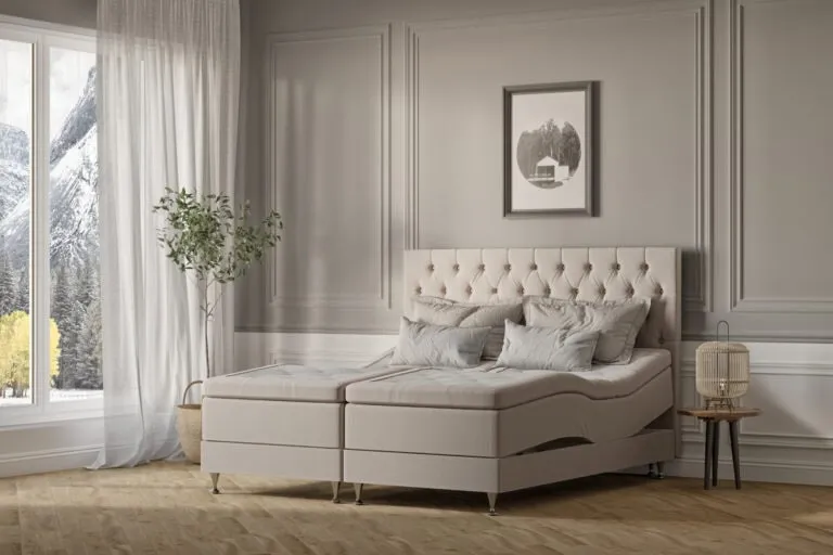 Modern sängfabrik i lugn ton med ångestfärgad sänggavel och mjuka kuddar.