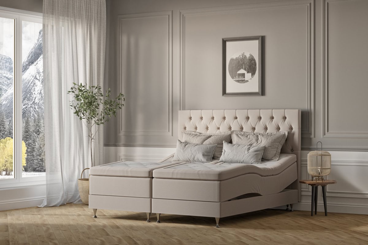 Modern sängfabrik i lugn ton med ångestfärgad sänggavel och mjuka kuddar.