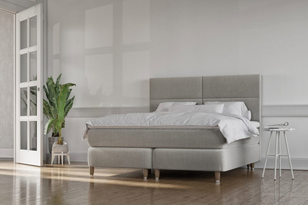 Ljust sänggavel och bekvämt sängsoffa i neutral färg.