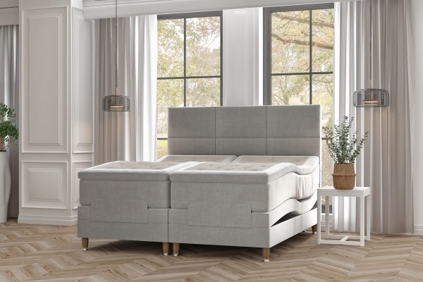 Havsängen och sängram i moderna gråtoner i en ljus sovrumsmiljö.