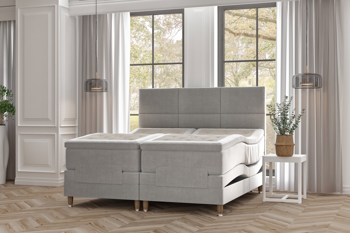 Havsängen och sängram i moderna gråtoner i en ljus sovrumsmiljö.