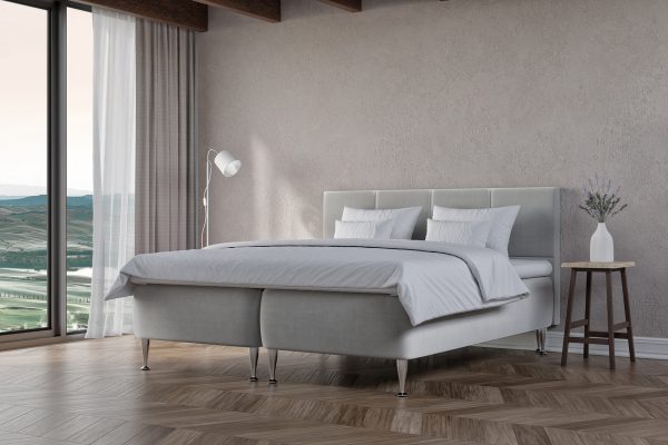 Elegant säng i modern design med bekväma sängkläder och utsikt över landskapet.