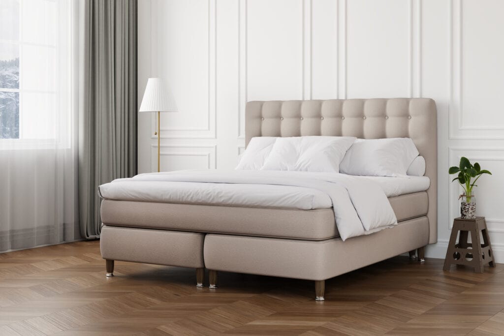 Bekvämt sängram med stoppad huvudgavel i modern design för sovrum.