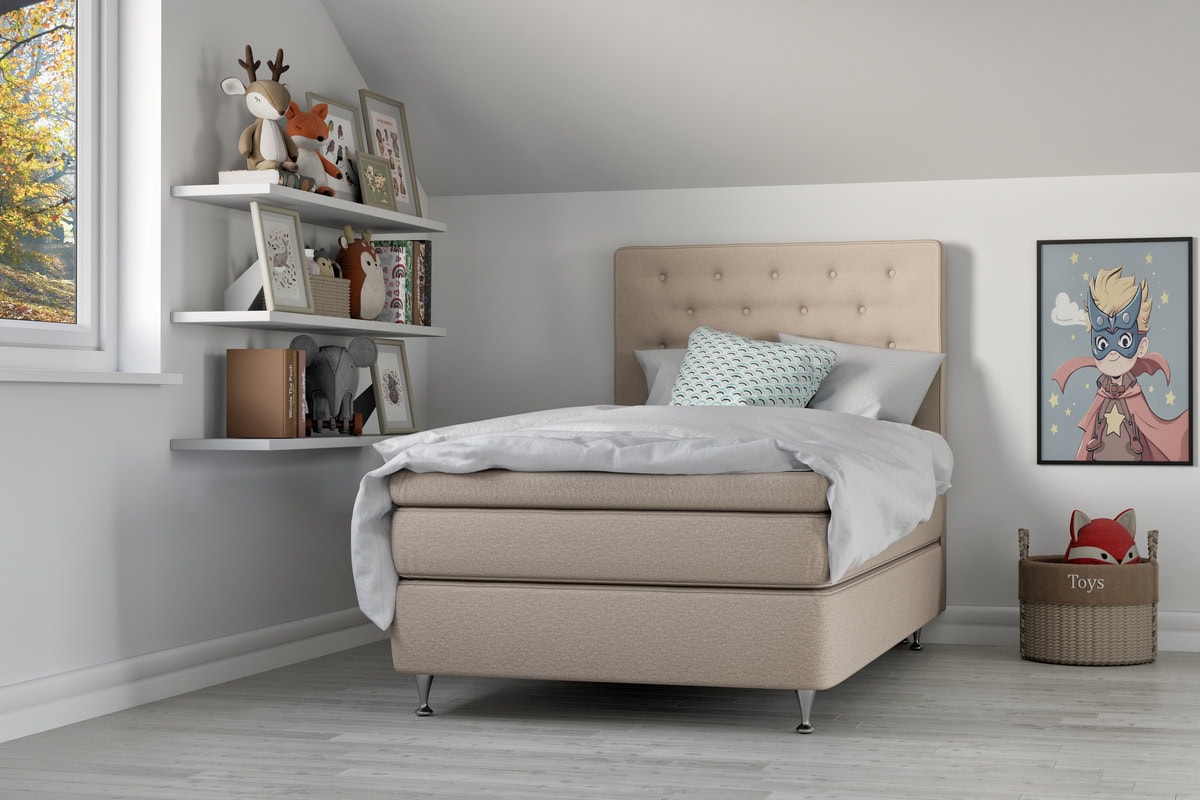 Madrass och sängram i ljus beige för barnrum.