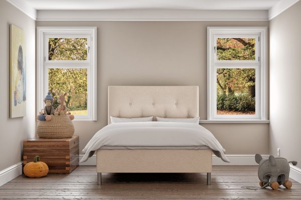 Möblerad sovrum med säng, fönster mot höstlöv, modern design och comfort.