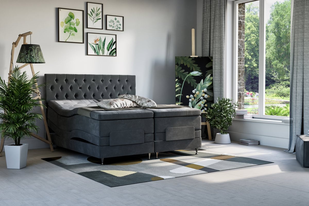 Mörkgrå säng med paneletändstolpe och växter i vitt krukor.