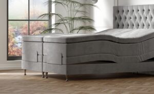 Elegant säng i grå sammet med modern design, perfekt för en lyxig sovmiljö.