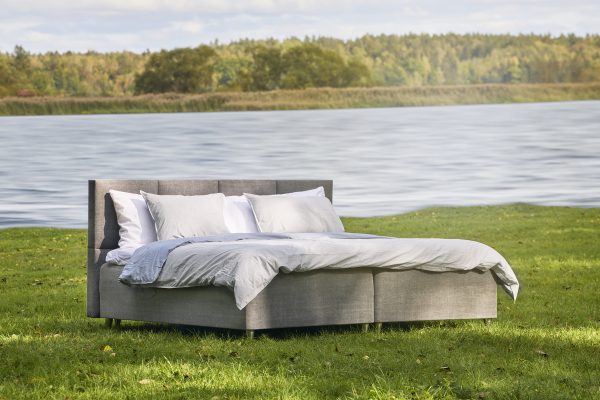 Säng i naturen vid vattnet för avkoppling och komfort.