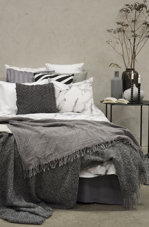 Madrasskydd i mörkgrått med textur för en mysig sovrumsmiljö.