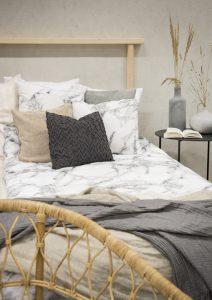 Kuddar i olika färger och texturer på säng från Sängfabriken i designmjöl.