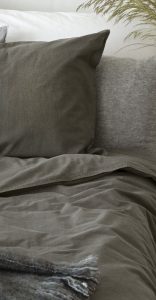 Mörkgrå bäddtextil i linne och bomull för en stilren sovrumsmiljö.