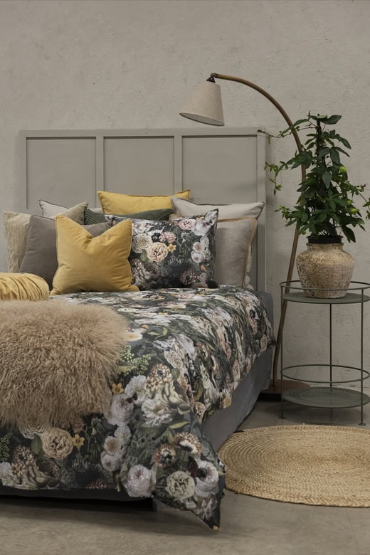 Mjuk och stilren säng med vackra textilier och prydnadskuddar för en mysig sovmiljö.