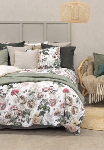 Lakan med blommönster och moderna kuddar i sovrummet från Sängfabriken.
