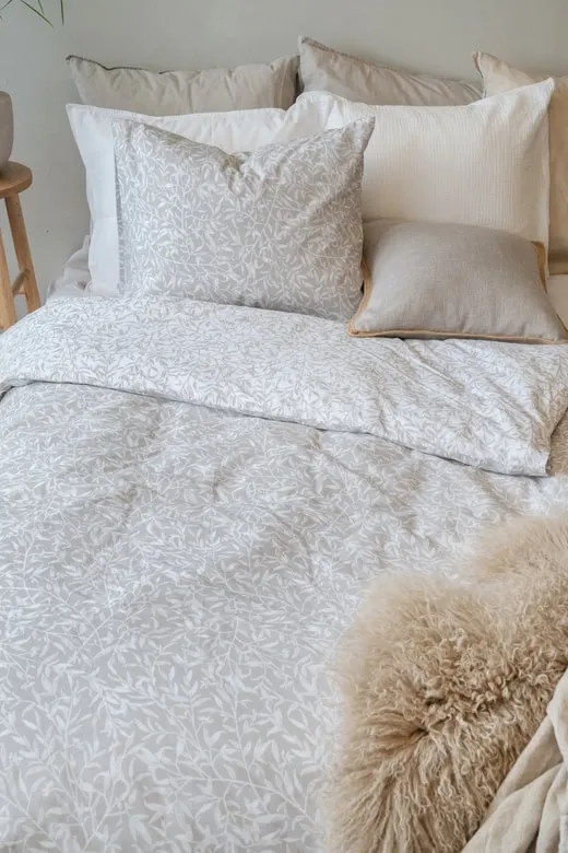 Lakan med bladmotiv i naturfärger, specifik för Sängfabriken, skapar en lugn sängupplevelse.