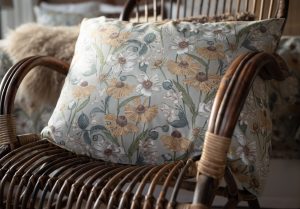 Fåtölj med blomstrande dekorativt kuddfodral i miljö inspirerad av naturen.