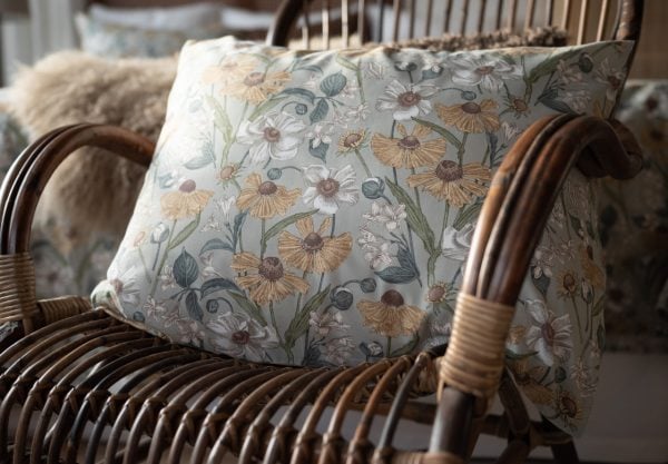 Fåtölj med blomstrande dekorativt kuddfodral i miljö inspirerad av naturen.