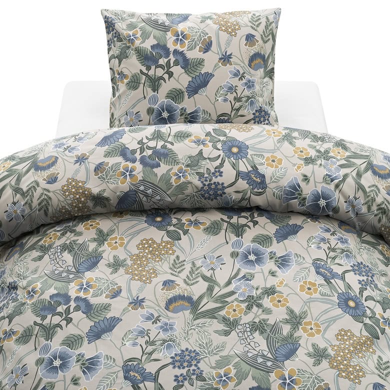 Mönstrat sängklädesset med blommor i blå, gul och grön nyanser.