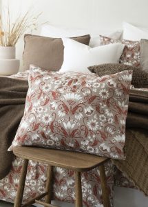 Frottécket med blomster- och växtmotiv i beige och vitt, elegant prydnadspåse.