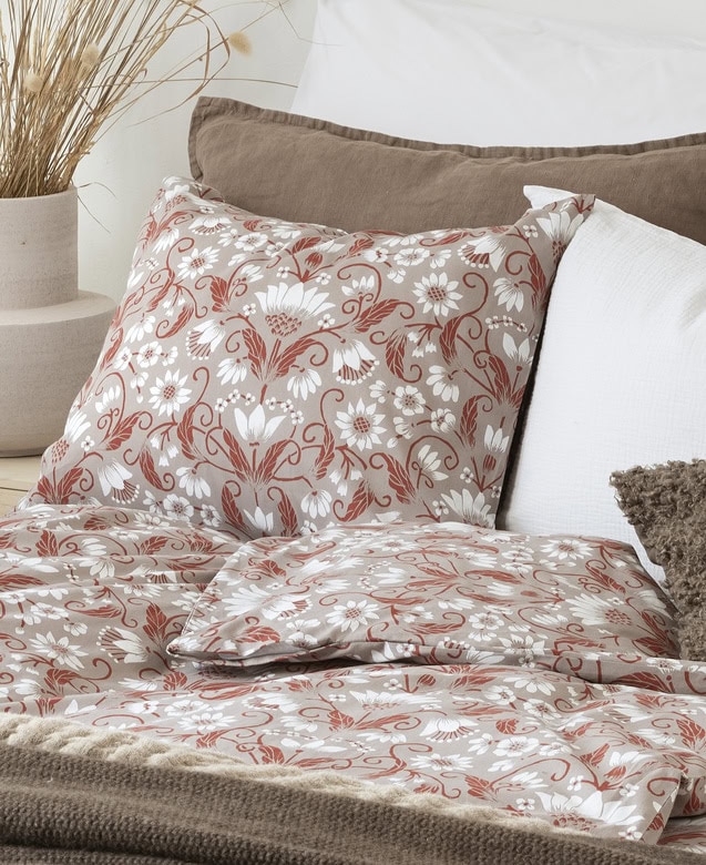 Mönstrat sängkläder med blommönster, i lugna jordnära toner perfekt för sovrum.