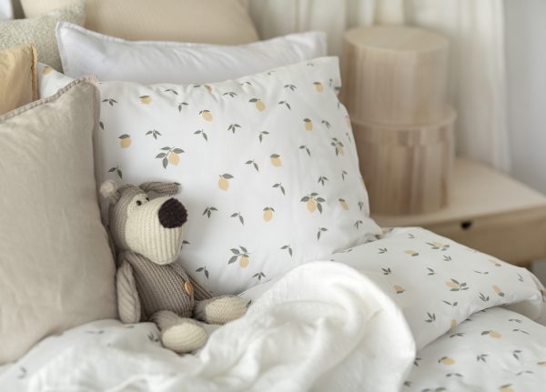 Mysig säng med naturnära sängkläder och inredning, perfekt för en avkopplande sovmiljö.