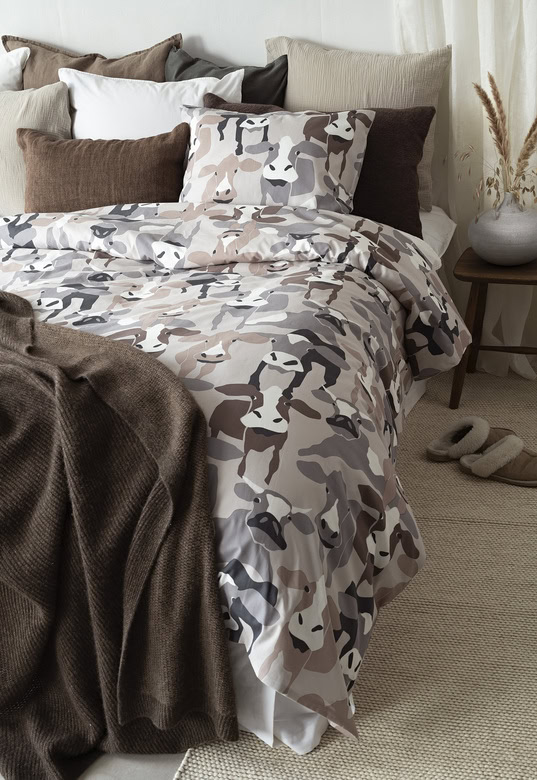 1. Mönstrad sovrumsbädd med kamouflagedesign och mysiga kuddar.