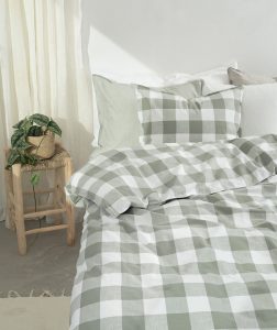 Mjukt sängklädesset i grått och vitt med rutmönster för en stilren sovrumskänsla.