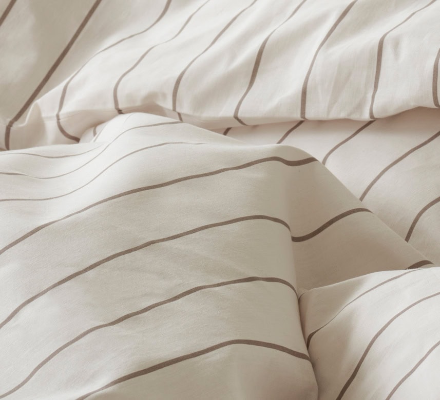 Mjukt och stilrent sänglinne med randiga mönster, perfekt för en skön nattsömn.