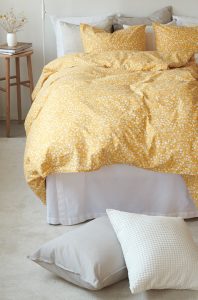 Mjuk, gul blomsterbäddad säng för en mysig sovupplevelse.