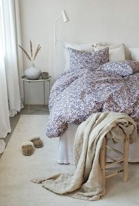 Modernt sovrum med bomullslakan och fluffiga kuddar för skön sömn.