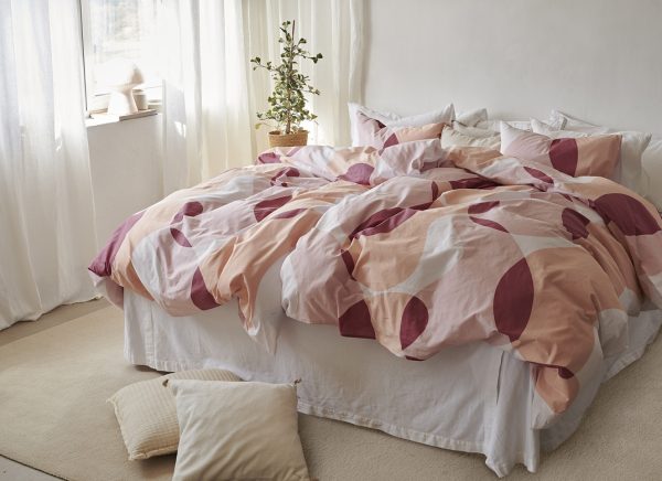 Mönstrat sängset med modern design, jordsnära färger för en mysig sovrumsmiljö.