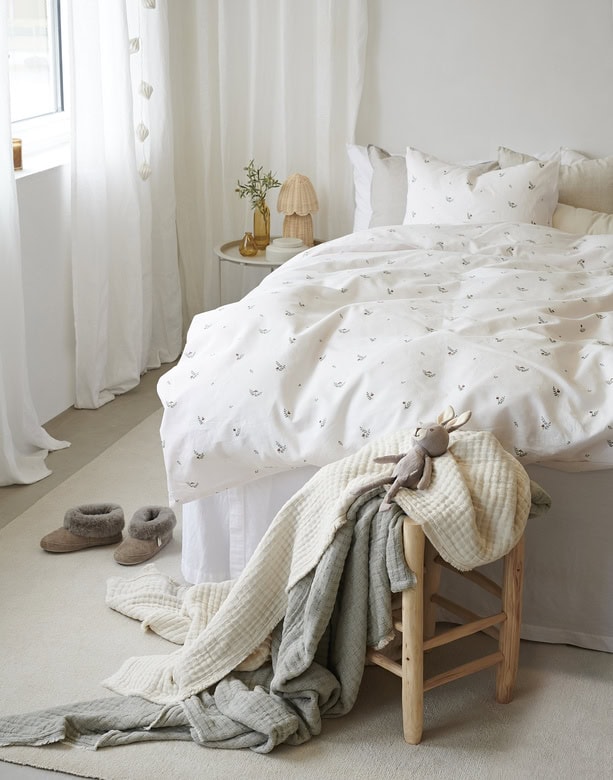 Lakan i naturnära vita toner med subtila mönster för en skandinavisk sovrumskänsla.
