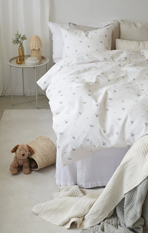 Mjuka vit sängkläder med blommig detalj, perfekt för en mysig sovrumsmiljö.