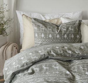 Ljusgrått julmotivbäddset med renar och snöflingor från Sängfabriken.